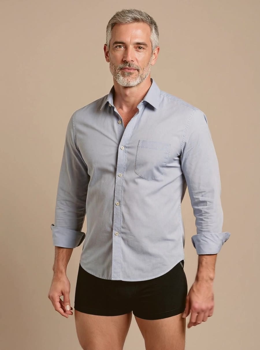 Man in his fifties wearing a light blue shirt and black Tarrock boxer briefs